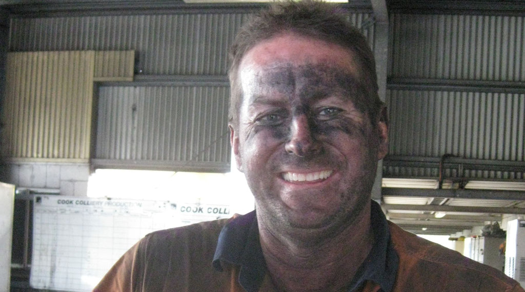 A man covered in black coal dust from working in the mines.