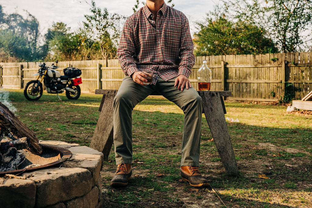 Man sitting next to fire while drinking 