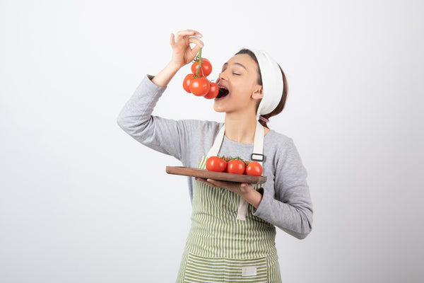Young woman eating tomatoes.