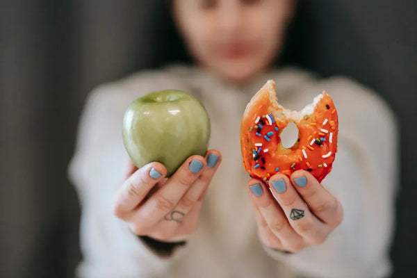 woman deciding on apple or donut