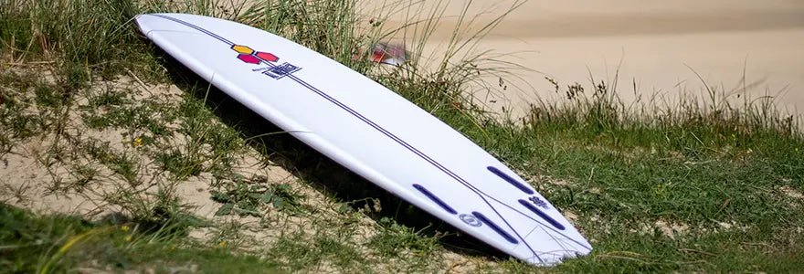 A Channel Islands Spine-Tek surfboard on a beach
