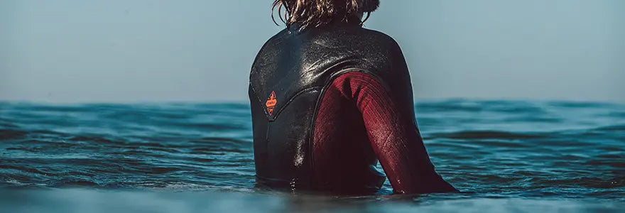 A surfer wearing an O'Neill Hyperfreak Fire wetsuit in the ocean.