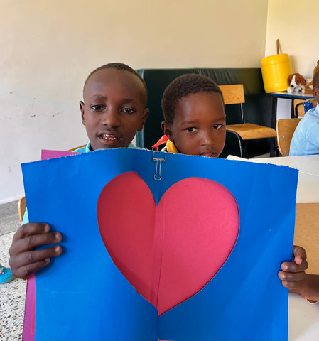 John and Jayden from the Ubuntu Life Foundation holding a Valentine's day card they made together for our donors!