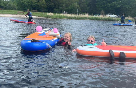 children and balloons on paddleboard