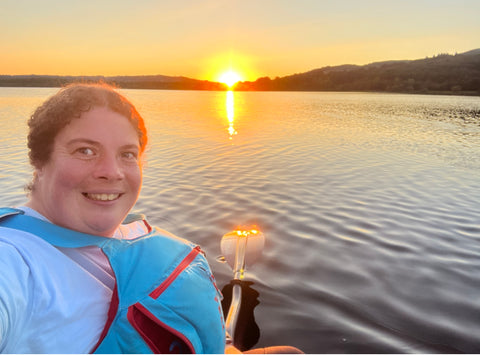 Sarah Thomson, Och Aye Canoe Ltd Director, in kayak with sunset in background