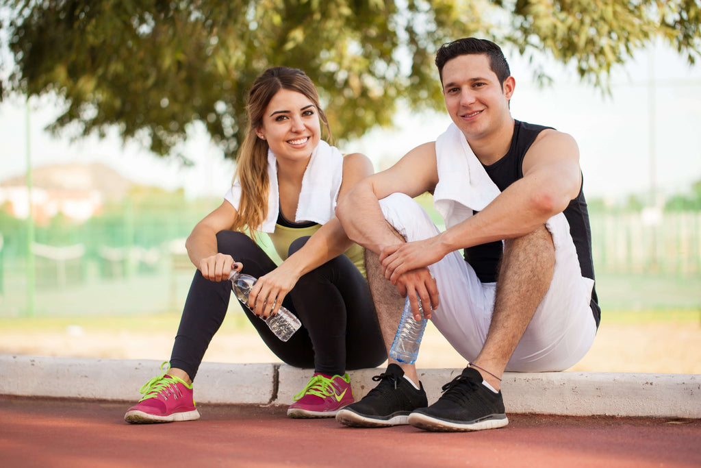 man and woman sitting on curb after running