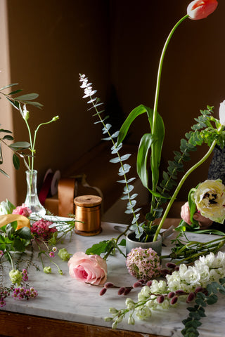 Préparation de fleurs pour l'Ikebana.  Roses, tulipes et autres fleurs et branches préparées pour la composition florale.