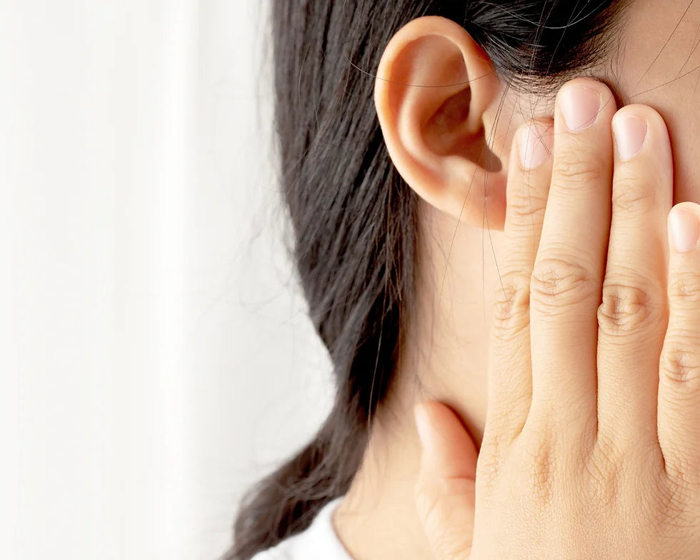 The woman is checking her ears.
