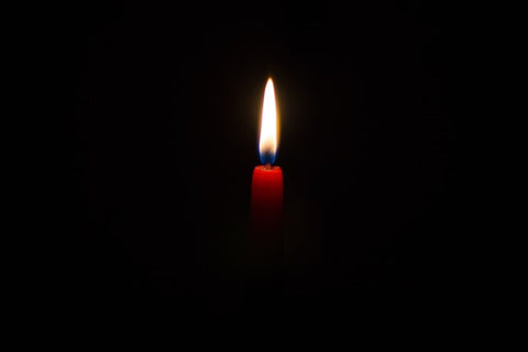 single candle in a black room