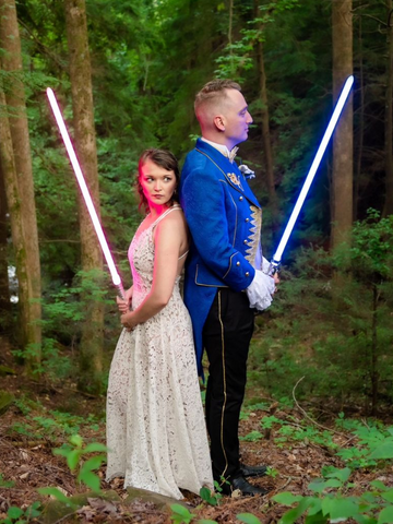 une mariée et un marié tenant tous deux des sabres laser personnalisés de SaberX pour rendre leur jour de mariage encore plus Jedi-licious.