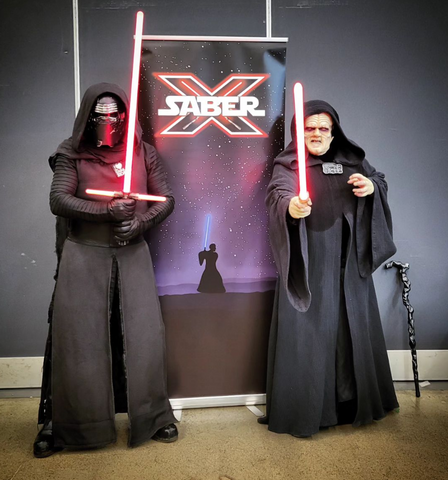 two people dressed as kylo ren and the emperor holding their star wars lightsabers as part of their costumes. order now for halloween.