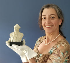 lafayette shoppe owner holding a bust of the Marquis de Lafayette smiling