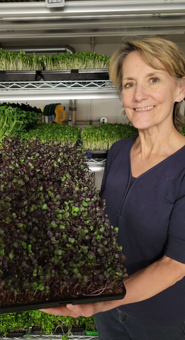 Image of Mary Jo Gallaway, owner, of Tri-County Microgreens holding a tray of Red Radish