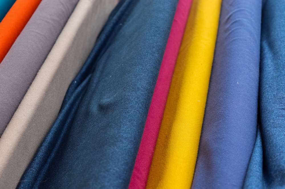 Detailed close up view on samples of cloth and fabrics in different colors found at a fabrics market.