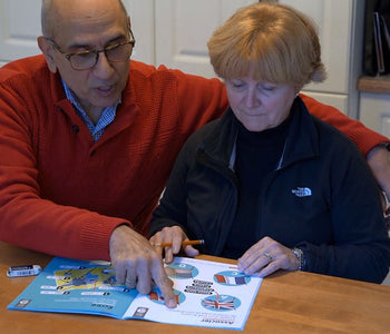 Elderly couple helping eachother do the Spark Your Mind activities.