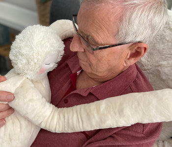 Older man holding the HUG, the sensory companion, designed for people living with dementia.