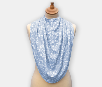 The dignifying protective pashmina bib for older adults in the light blue with white polka dots pattern.