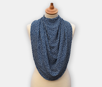 The dignifying protective pashmina bib for older adults in the navy blue with white polka dots pattern.