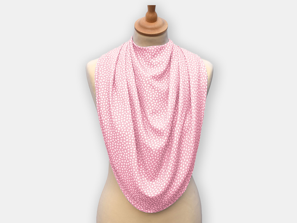 The dignifying protective pashmina bib for older adults in the pink with white polka dots pattern.