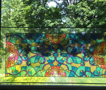 Colored peal and stick transom on a window giving a stained glass effect with the sunlight.
