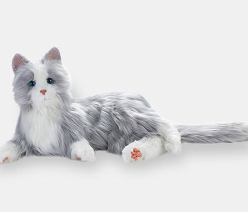 The silver interactive cat from Joy for All, for people living with dementia, laying on its side.