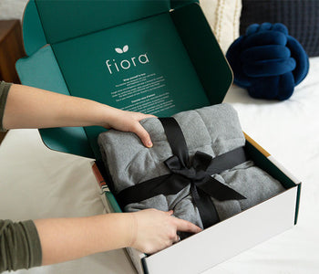 Person unboxing the Fiora weighted sensory blanket.