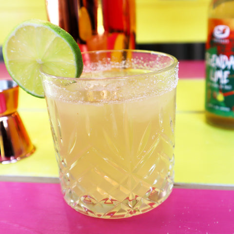 Een kombucha margarita cocktail in een laag glas met Legendary Lime kombucha en een limoentje