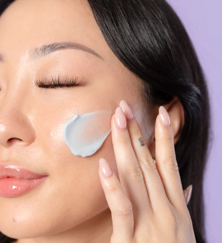 Person applying skincare patches to cheeks with a dropper.