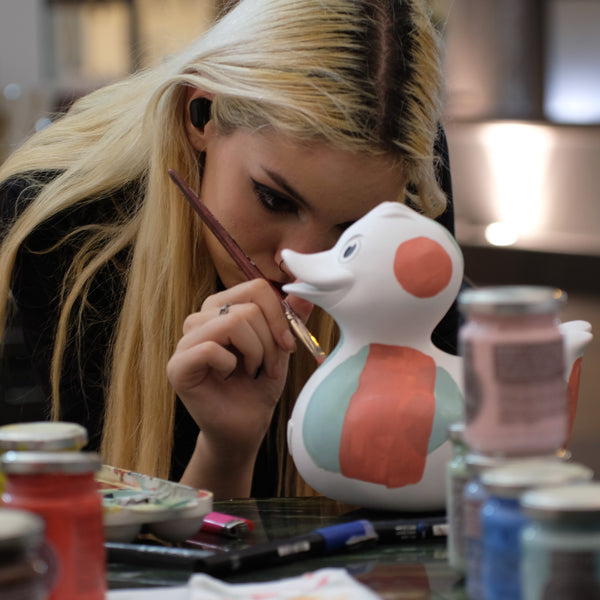 ION griechische Künstlerin bemalt eine Ente aus Kunstsandstein