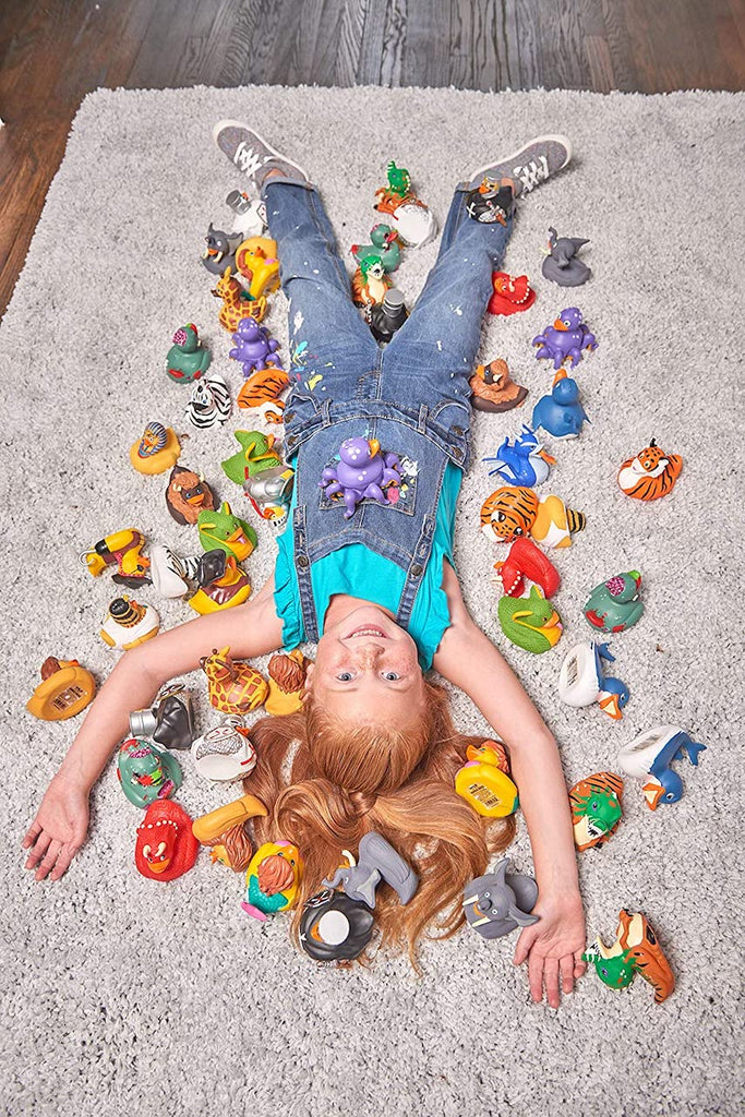 Ein Mädchen liegt mit seht vielen Wild Republic Badeenten auf einem Teppich