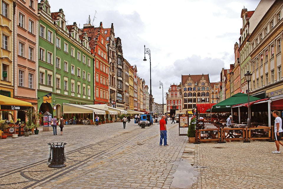 Colorful facades of buildings on a historic European street with pedestrians and outdoor cafes.