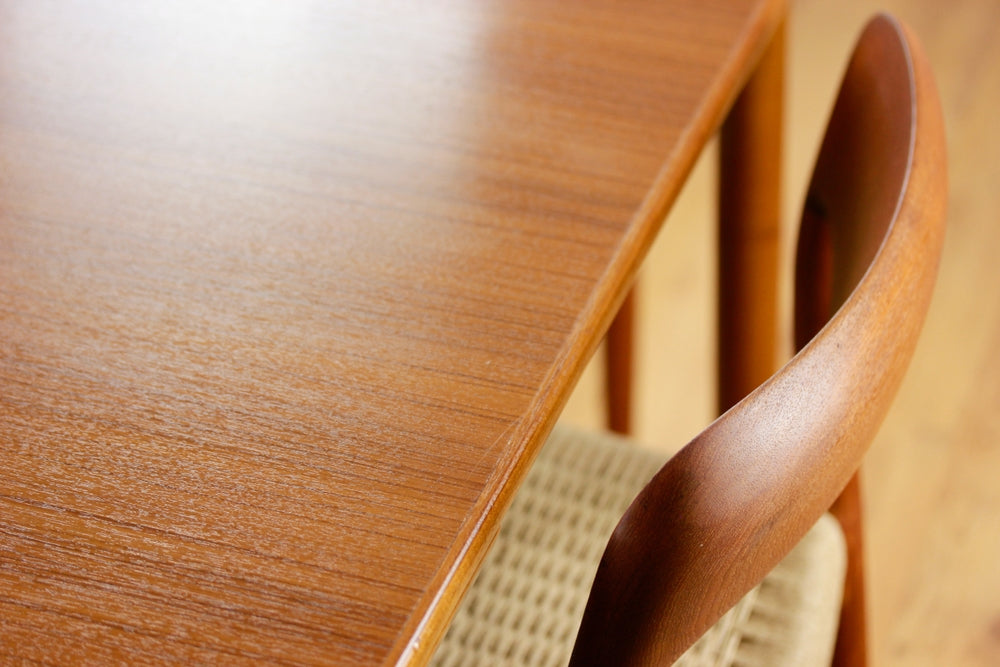 A Mid Century Teak Dining Table with four chairs from the 50s 60s Danish Design Vintage Dining solid wood Modern antique 50s 60s isolated on white wall in modern living room closeup side front view