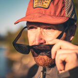 An ADV motorcycle rider putting on sunglasses.