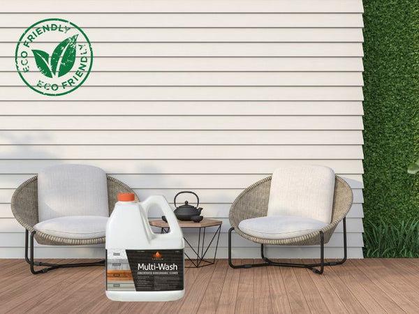 The bottle of Sansin Multi-Wash product is found on a wooden patio. On the patio, there are also two chairs with a small table between them. In the background, there is the cream white wall of the house.