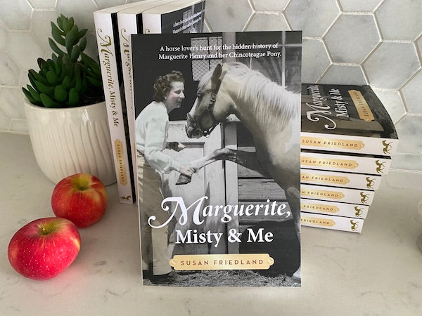 Display of Marguerite Henry biograph on white kitchen counter with apples