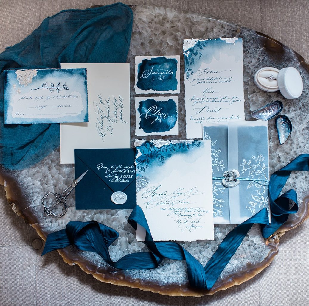 Vellum with white printing for wrapping an invitation, hand made paper and calligraphy for a romantic and glamorous wedding style. Navy and Silver colour scheme for the wedding