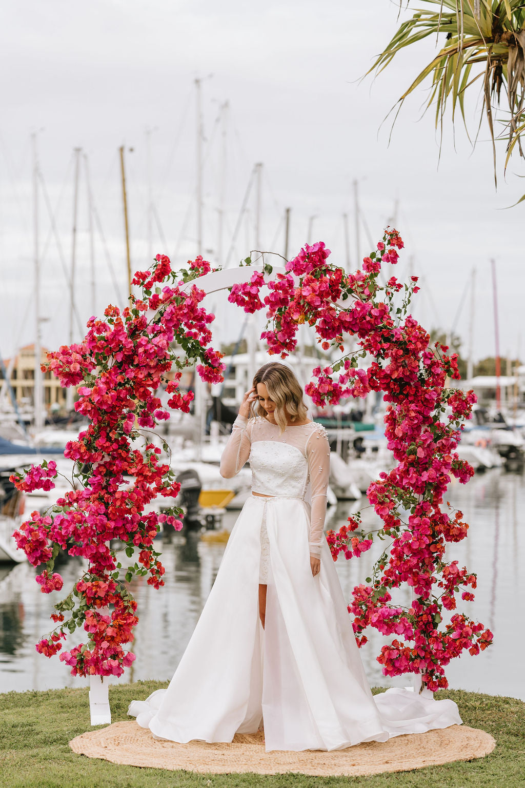 girl under bougainvillaea arch for wedding overlooking the marina at Mooloolaba