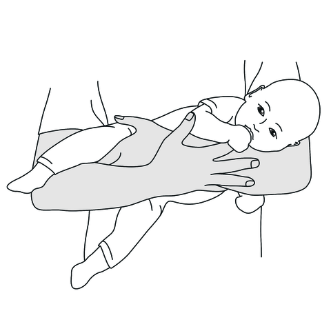 Ein Baby wird im Fliegergriff vor der Brust eines Elternteils gehalten.