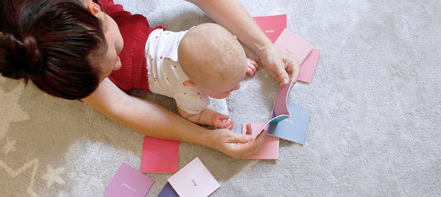 Mutter und Baby auf dem Boden betrachten Baby Signs Karten