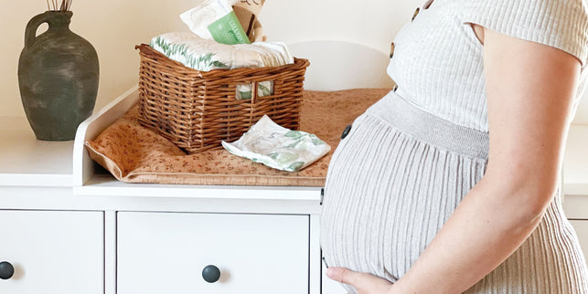 Schwangere streichelt Babybauch vor Wickeltisch mit LILLYDOO green Windeln 