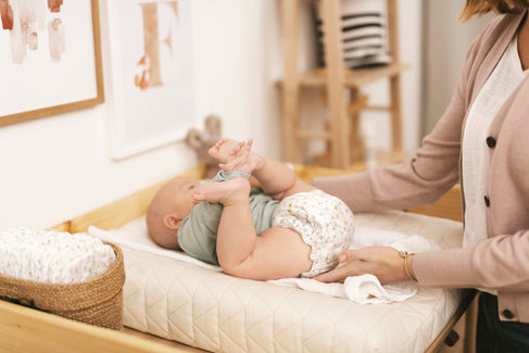 Mamá cambiando pañal a su bebé