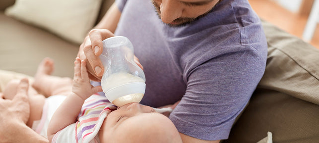 Padre allatta neonato con biberon