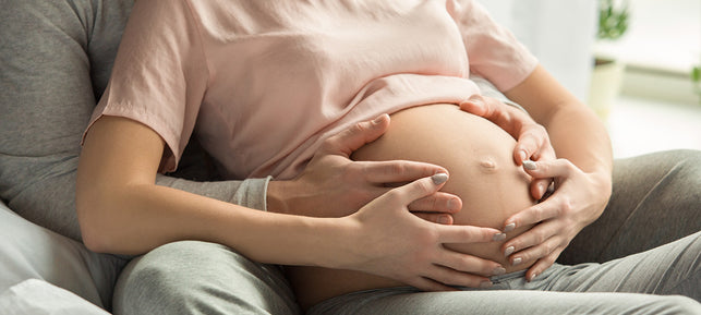 Madre e partner tengono le mani sulla pancia della mamma