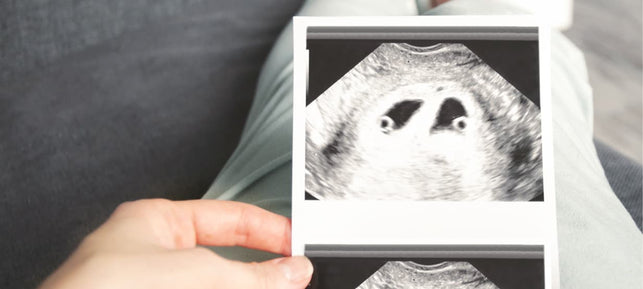 Schwangere betrachtet Zwillings-Ultraschallbild