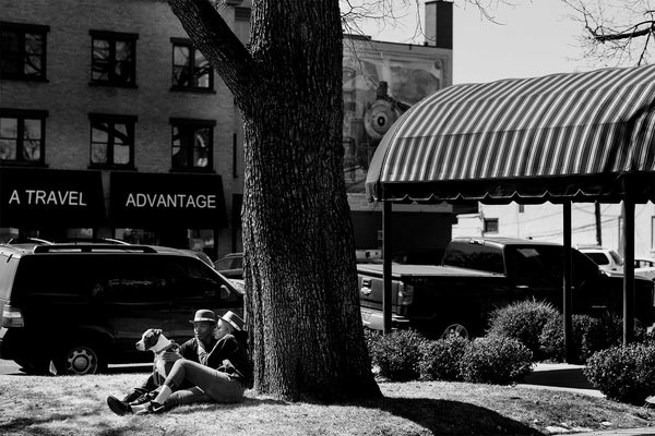 Couple sits under a tree during the St. Patrick's Day Parade