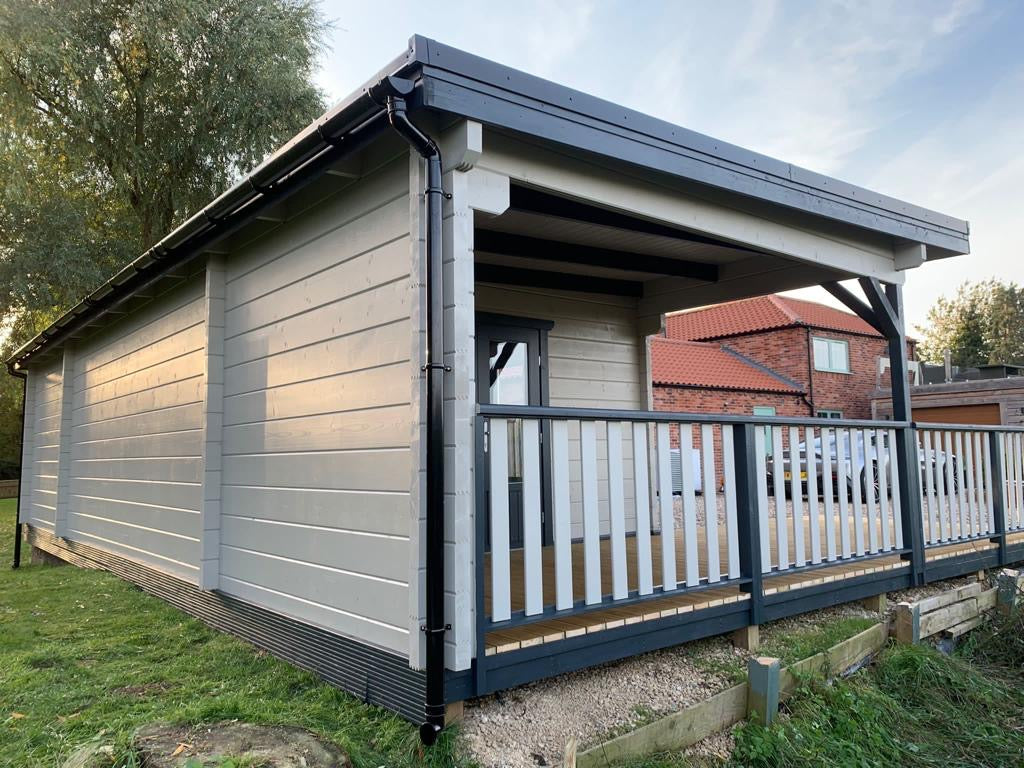 Exterior view of a luxurious 1 bed log cabin with decking designed by Timber Building Specialists.