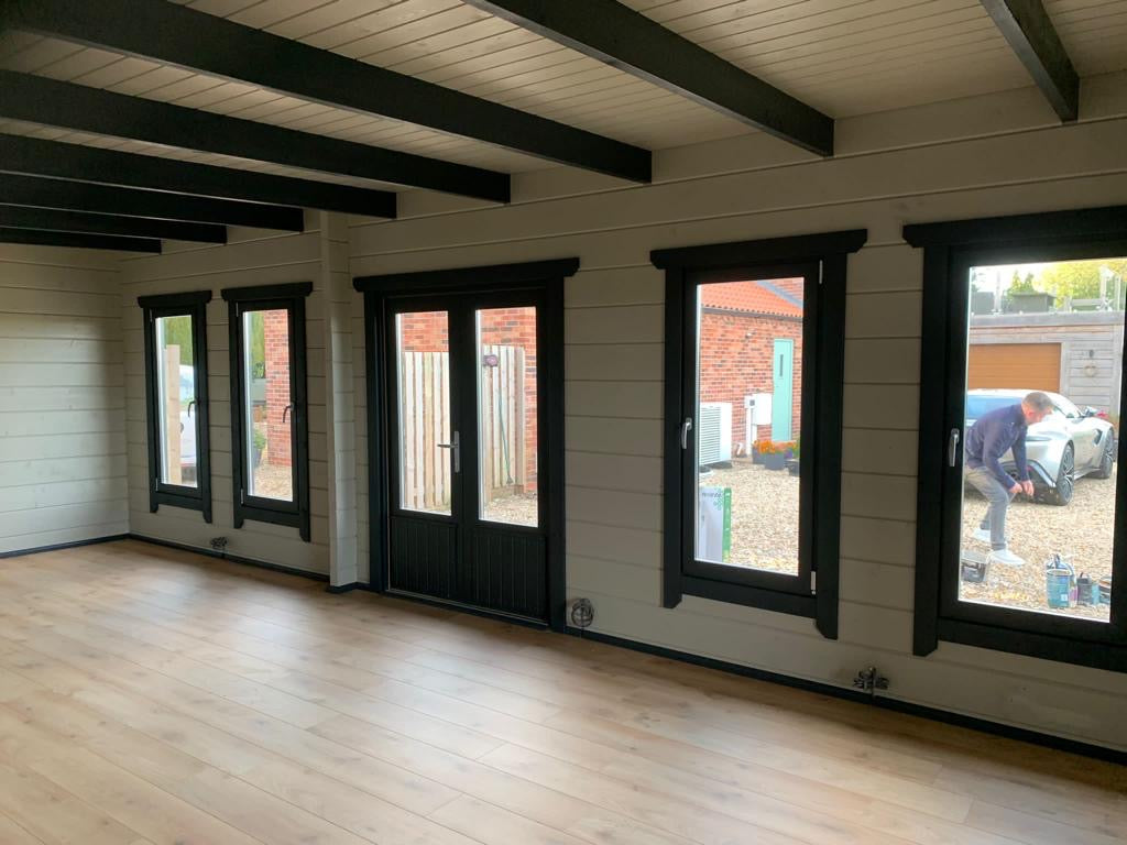 Spacious and well-lit interior of Timber Building Specialists’ 1 bed annex with large windows and French doors.