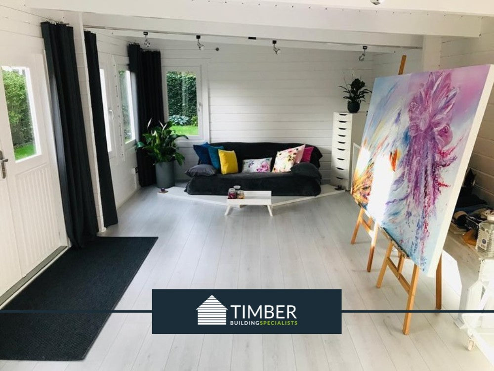 A beautiful log cabin art studio bathed in natural light, with a well-lit workspace and personal touches.