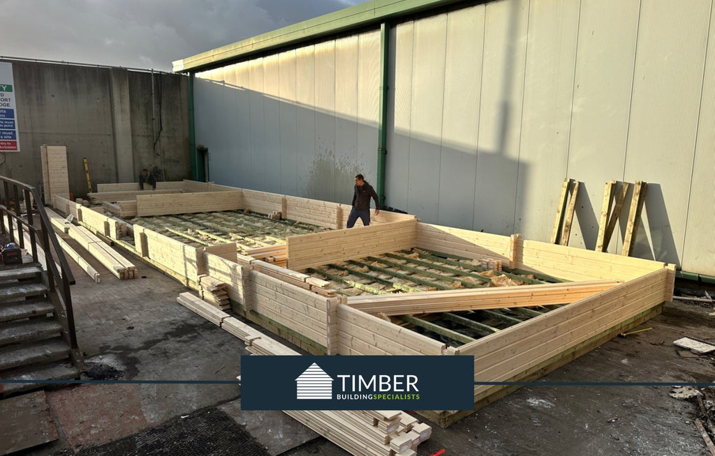 Early phase of the cabin's construction with Timber Building Specialists' craftsmen at work.