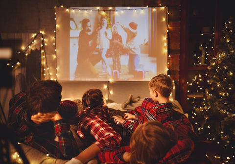 Family watches movie in holiday themed pajamas